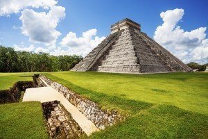 Monument of Chichen Itza on the green grass during summer in Mexico