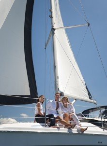 Group of friends having fun on a yacht with blue sky background